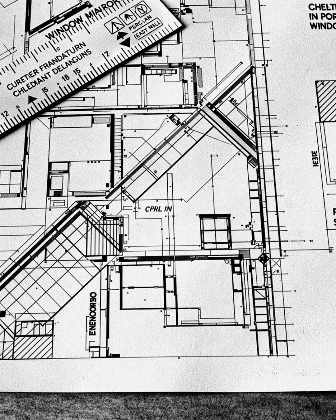Window shop drawings spread across a table with a pencil and a scale ruler.
