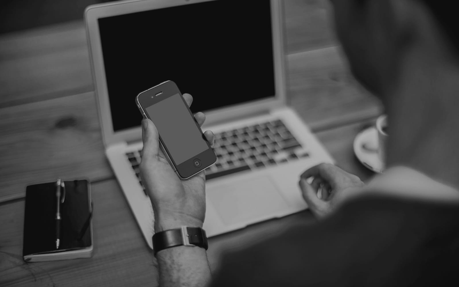 An owner at a laptop checks how the business appears on a phone.